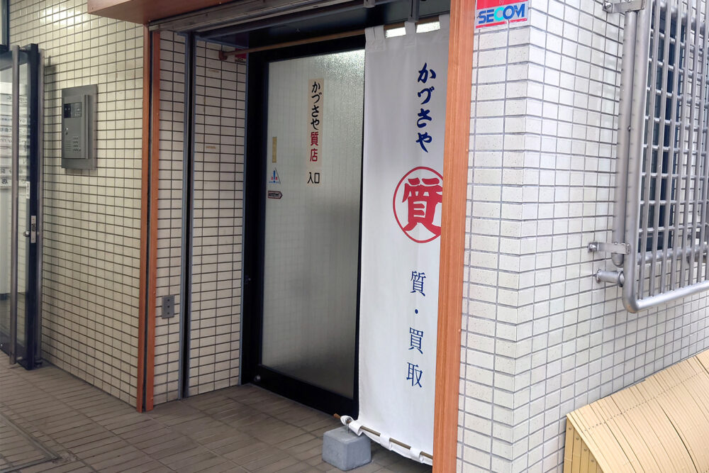 質・買取り用入口は白いのれんからお入りいただけます